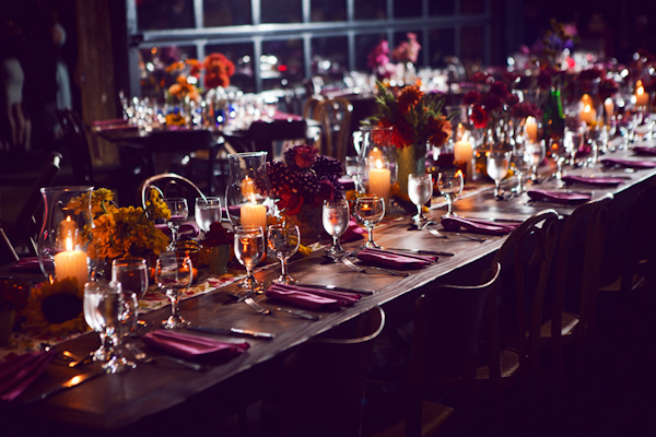 flowers and assorted candles line a long table in a warehouse reception site - vintage LA wedding at The Smog Shoppe photo by top Orange County wedding photographer Duke Images