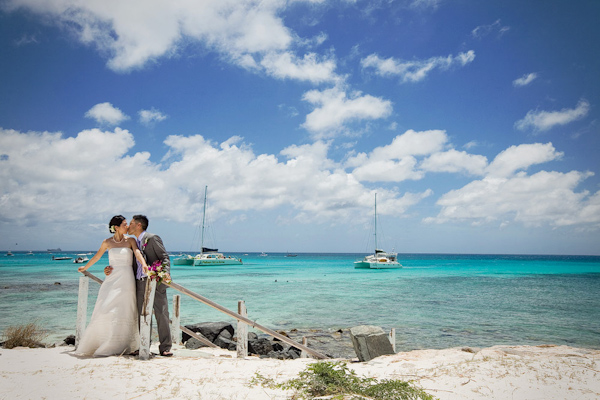 bride and groom kissing in gorgeous beachside location - photo by Kenny Kim Photography