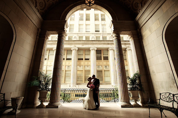 bride and groom kiss under columns and archway -  wedding photo by top Philadelphia based wedding photographers Langdon Photography