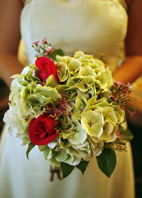 photo by New York based wedding photographer Merri Cry - close up of the brides bouquet 0 red roses surrounded by green and white flowers