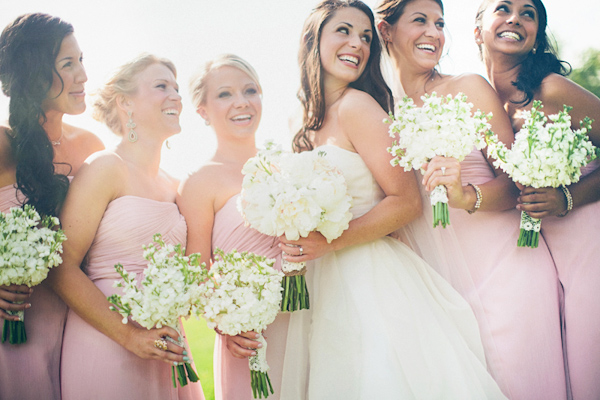 Photo of bridesmaids in pale pink dresses and white bouquets with the bride - Photo by The Schultzes