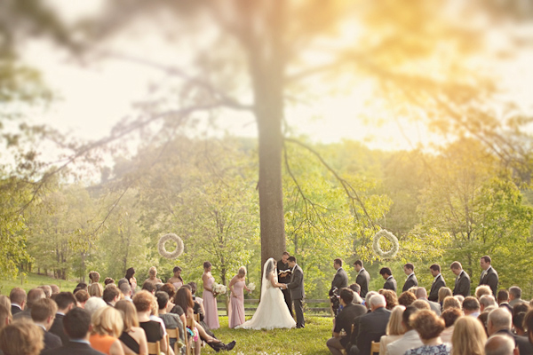 Sunny outdoor wedding ceremony photo by The Schultzes