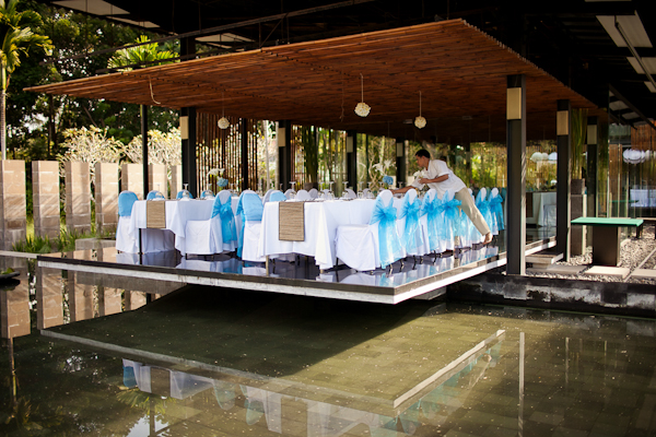blue ribbons tied on white chairs in reception area overlooking reflection pool - traditional Indonesian wedding in Bali - photo by Portland wedding photographer Bunn Salarzon