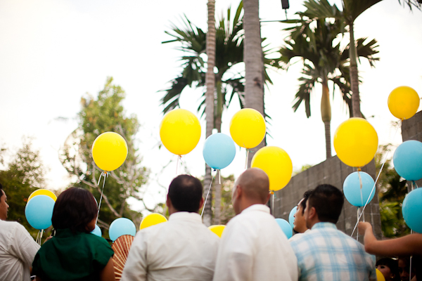 guests hold yellow and blue balloons to release - traditional Indonesian wedding in Bali - photo by Portland wedding photographer Bunn Salarzon
