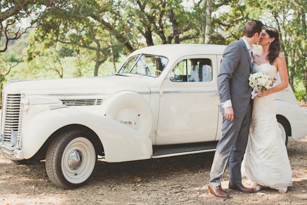 couple kisses in front of white vintage car - warm, sunny, Sonoma California vineyard wedding photo by California wedding photographers EP Love