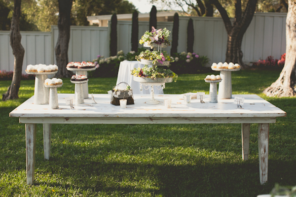 white wooden table setting with metal dessert stands and cupcakes - warm, sunny, Sonoma California vineyard wedding photo by California wedding photographers EP Love