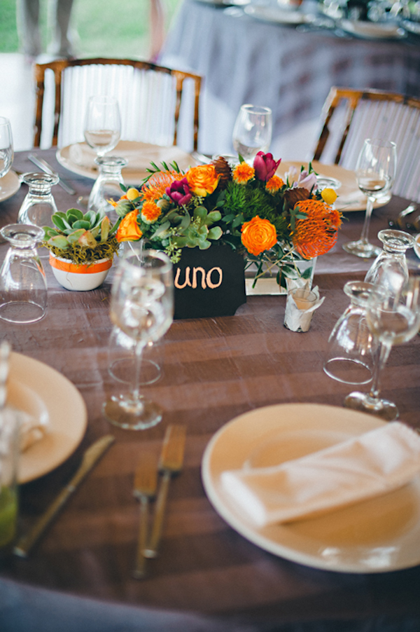 table setting with orange and dark pink flower centerpiece - Sayulita, Mexico destination wedding photo by Mexico wedding photographer Jillian Mitchell