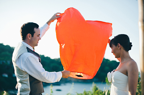 bride and groom release an orange lantern into the sky - Sayulita, Mexico destination wedding photo by Mexico wedding photographer Jillian Mitchell