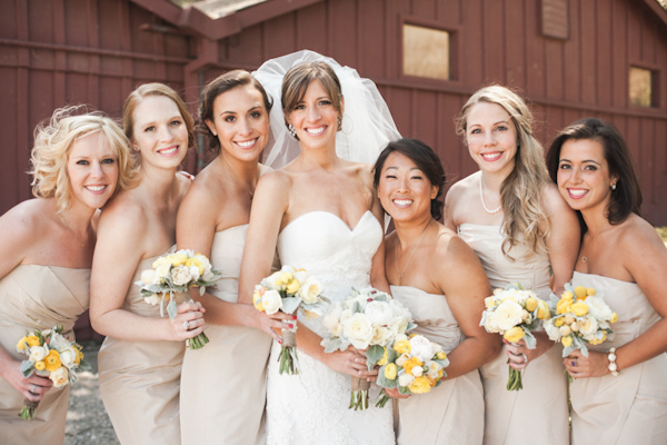 Bride and bridesmaids wearing nude dresses with yellow and white bouquets - Photo by Michelle Warren Photography