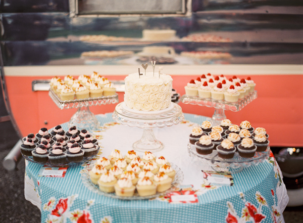 Cupcake and wedding cake table on blue and red tablecloth - Photo by Michelle Warren Photography