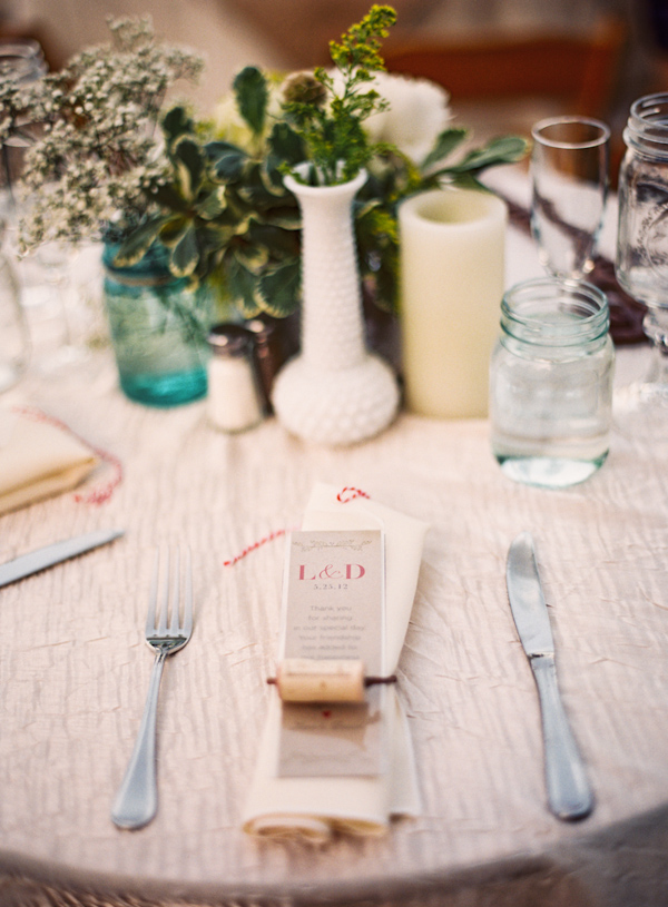 Geen plant centerpieces in eclectic vases and bookmark favor secured by wine cork - Photo by Michelle Warren Photography
