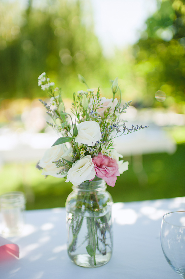 Pink and white rose table arrangement with organic greenery - Photo by Nordica Photography