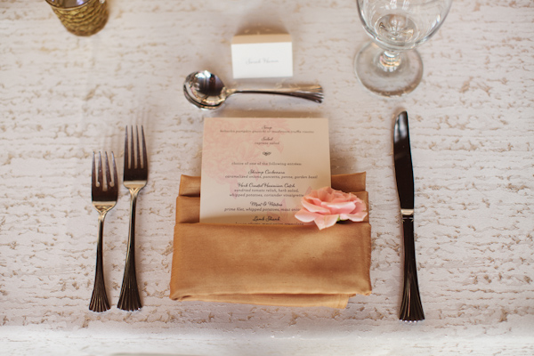 Wedding menu tucked in tan napkin with pink flower detail - Photo by Sara and Rocky Photography
