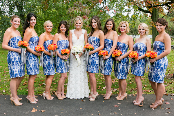 Blue and white patterned bridesmaid dresses with orange bouquets - Photo by Sarah Tew Photography