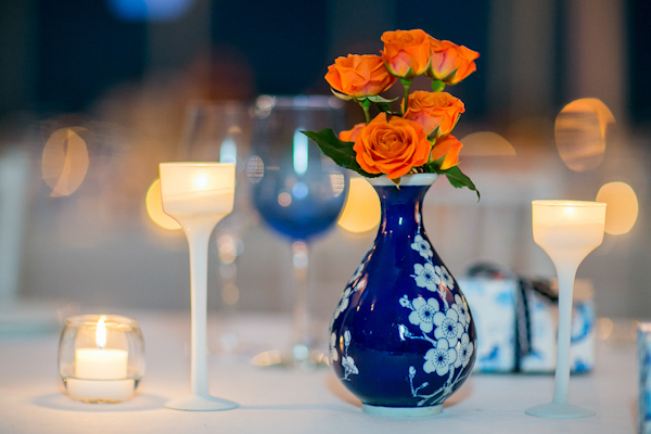 Vibrant orange roses in navy blue and white floral vase - Photo by Sarah Tew Photography