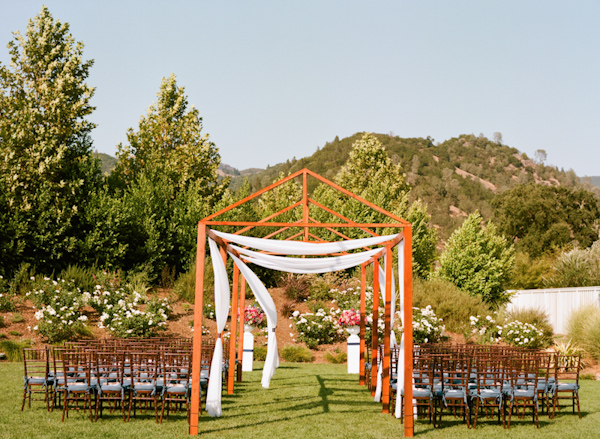 Outdoor wedding ceremony in beautiful Napa Valley with wooden aisle structure - Photo by Sylvie Gil Photography