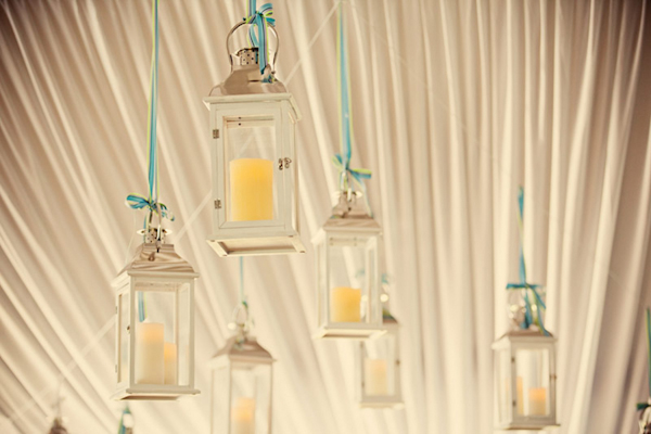 candles hang in class lanterns from tent ceiling - preppy New York Sagamore resort wedding photo by New York wedding photographer Tracey Buyce