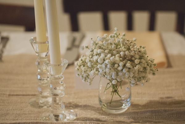 Small baby's breath reception table arrangement on burlap tablecloth - Photo by Whitewall Photography