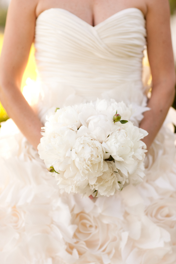 bride wearing an ivory strapless sweetheart cut ruffle wedding gown holding a white and ivory bouquet -  photo by Washington DC wedding photojournalist Paul Morse