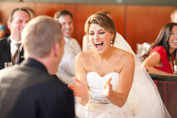 image of the beautiful laughing bride at the reception - bride is wearing white pearl teardrop earrings - photo by Washington DC wedding photojournalist Paul Morse