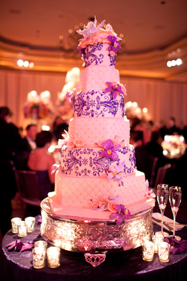 White six layered wedding cake with purple whimsical decor, purple floral accents, and a silver cake stand - photo by Washington DC wedding photojournalist Paul Morse