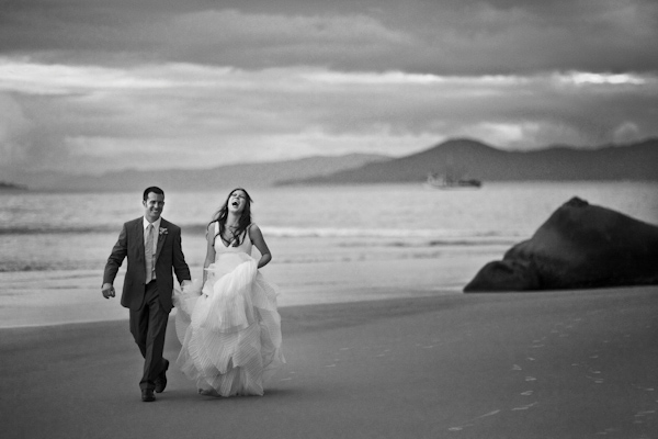 photo by destination wedding photographer Vinicius Matos - gorgeous black and white photo of bride and groom laughing on the beach