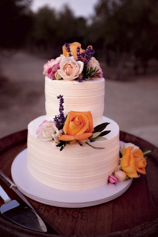white wedding cake with pink and orange flowers for vineyard wedding at Sunstone Winery, photo by Ashleigh Taylor Photography