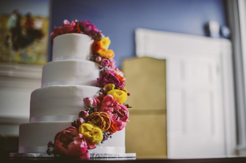 bright flowers on clean white tiered cake, photo by The Oberports