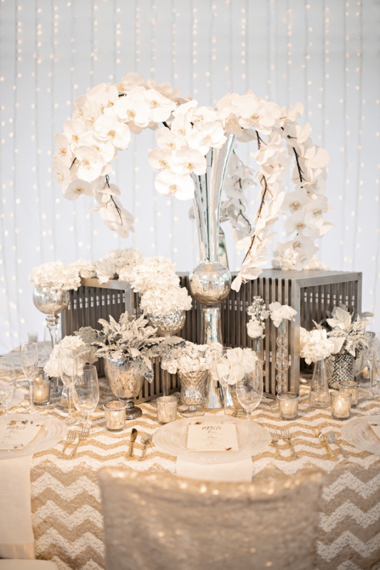 white orchid centerpiece on gold chevron print table, photo by Kristen Weaver Photography
