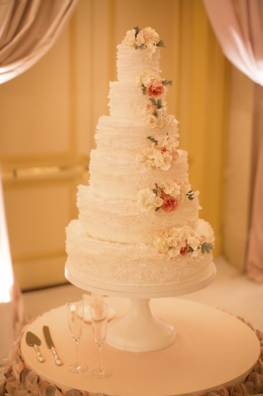ruffled white tiered wedding cake with pink florals, photo by Ira Lippke Studios