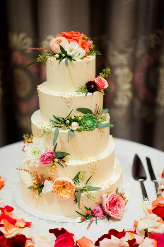 tall white cake accessorized with flowers and succulents