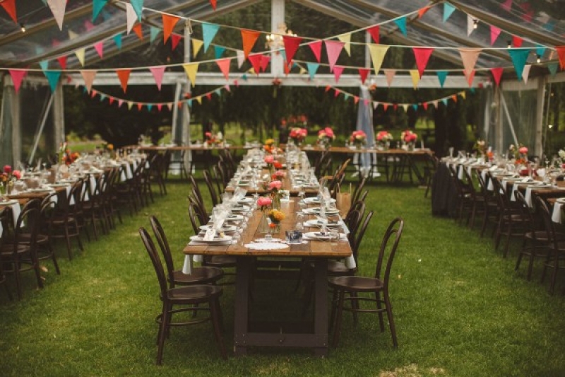 Colorful wedding tent reception bunting farm tables