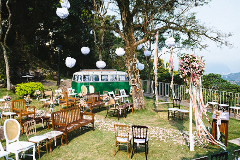 Eclectic backyard wedding ceremony different chairs hanging poufs