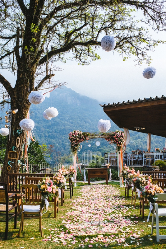 Eclectic backyard wedding ceremony aisle flower petals hanging poufs