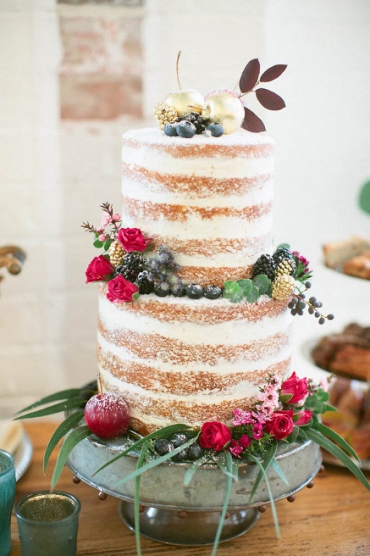 naked cake powdered sugar red roses berries gold accents