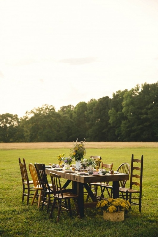 outdoor reception with wooden table and chairs