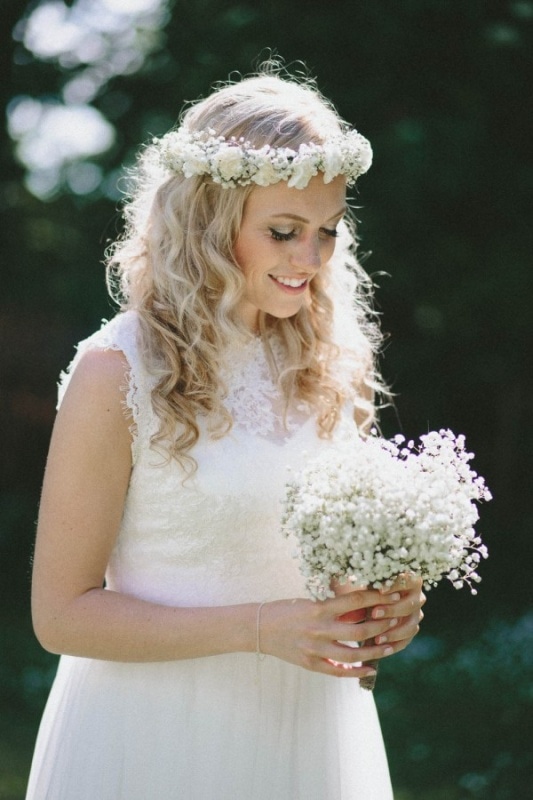 beautiful blonde bride with curled hair and a white floral crown