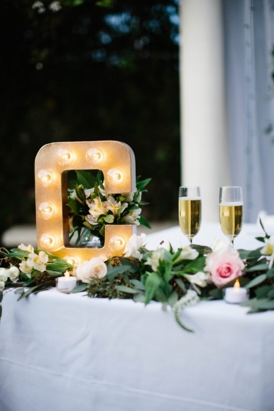 letter marquee and leaf garland on newlyweds table