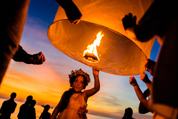 gorgeous portrait of little girl releasing wish lantern at beach front wedding reception - photo by top Thailand-based destination wedding photographer Julian Wainwright of Wainwright Weddings | Junebug Weddings gorgeous portrait of little girl releasing wish lantern at beach front wedding reception - photo by top Thailand-based destination wedding photographer Julian Wainwright of Wainwright Weddings | Junebug Weddings