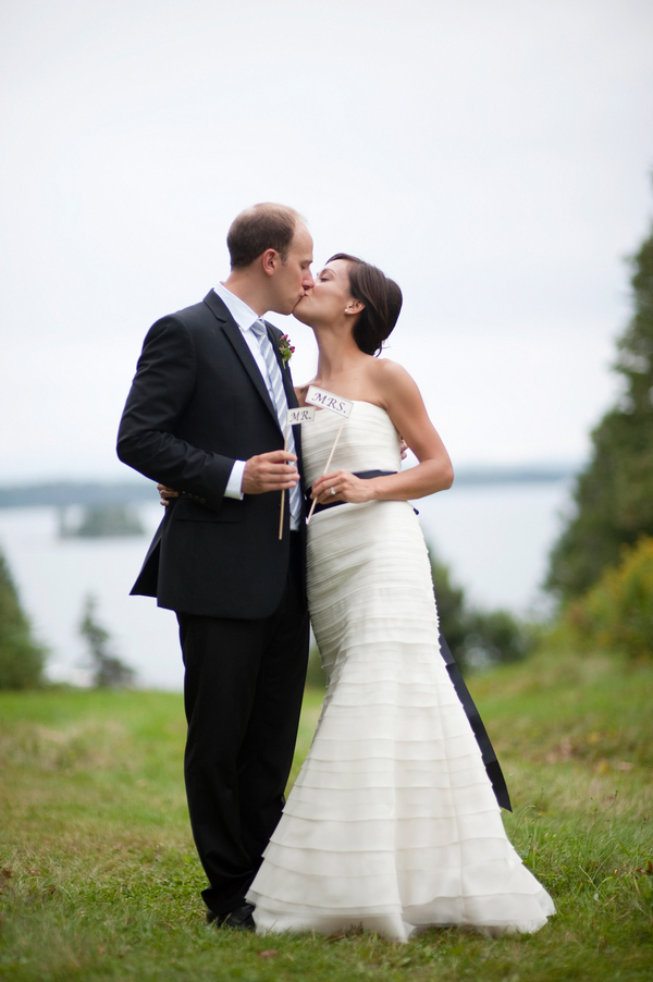 The bride and groom kiss while holding signs that say “Mr.” and “Mrs.”- New England wedding - Bar Harbor Sorrento, Maine - photos by top east coast wedding photographers Justin and Mary New England wedding - Bar Harbor Sorrento, Maine - photos by top east coast wedding photographers Justin and Mary