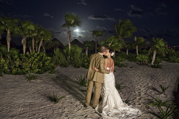 gorgeous night shot of the happy couple kissing on the beach with palm trees in background - Riviera Maya, Mexico destination wedding - photo by Dallas based wedding photographer Jeremy Gilliam