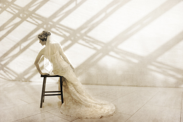 beautiful sepia toned portrait of bride gracefully leaning on chair - fine art wedding photo by top Dallas based photographer Paul Ernest