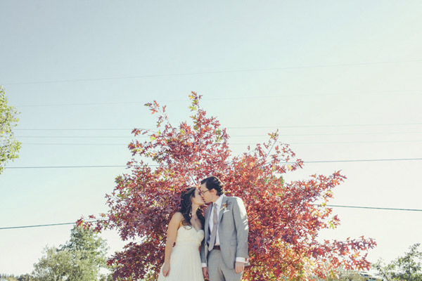 wedding photo of couple kissing in front of autumn trees by Paco and Betty | via junebugweddings.com | 