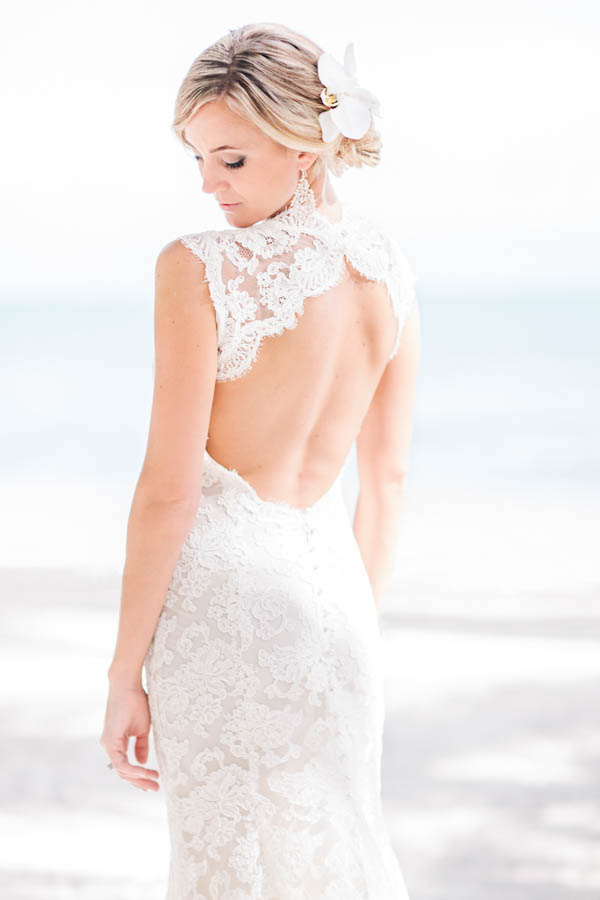 elegant lace beach bridal gown and floral hair piece