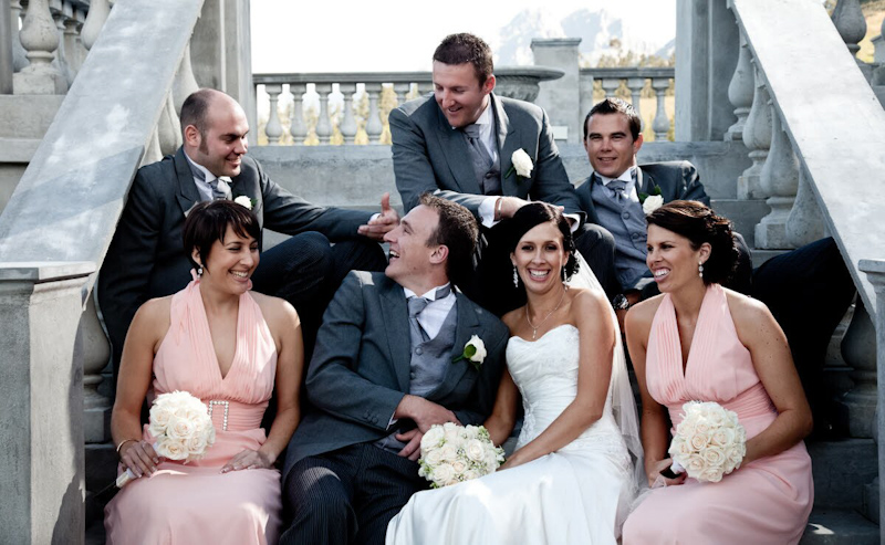 Wedding party sitting on staircase , Bride in white dress