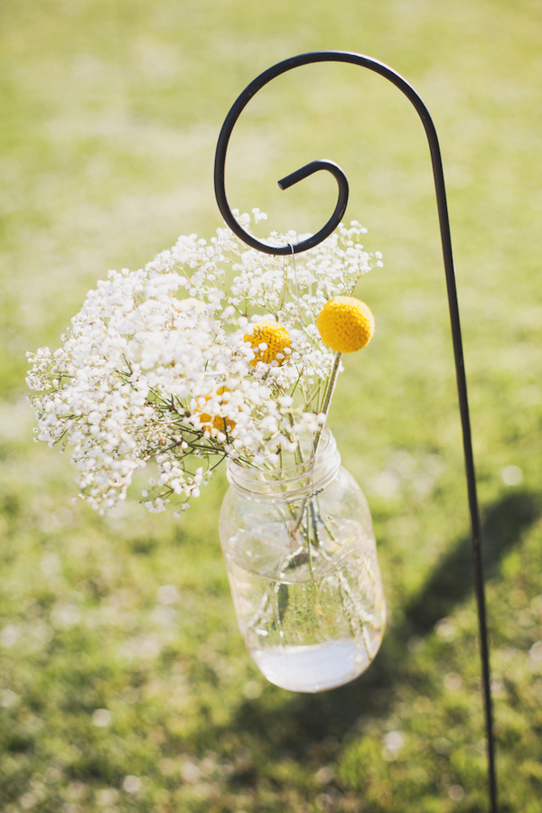 Hanging mason jar vase with modern yellow flowers and baby's breath - Photo by Michelle Warren Photography