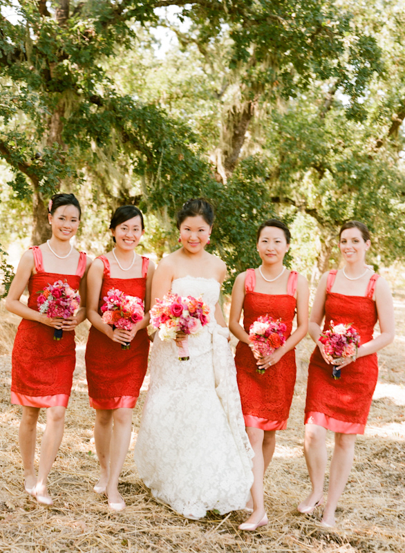 Beautiful bride with bridesmaids wearing short, bright red dresses - Photo by Sylvie Gil Photography