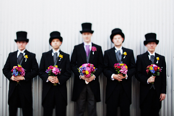 The Groom And Groomsmen Pose With Bright Bouquets In This Group