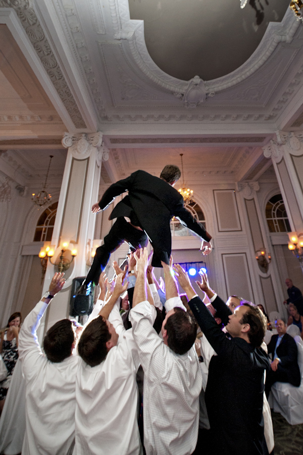 groom is tossed in the air by his groomsmen during reception - wedding ...