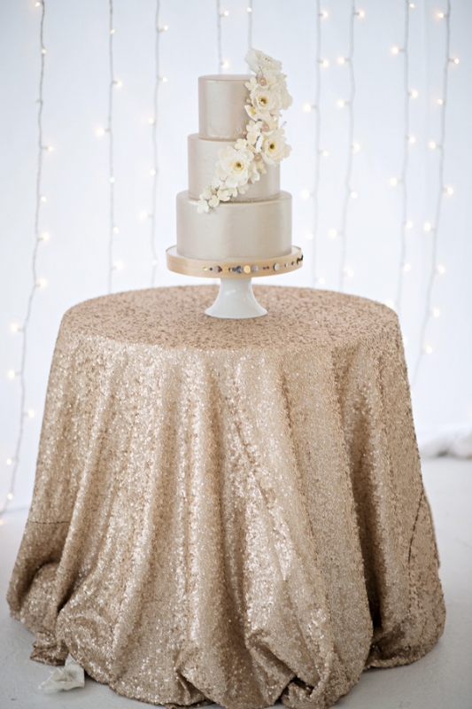 silver tiered wedding cake with white flowers on glitter gold table, photo by Kristen Weaver Photography